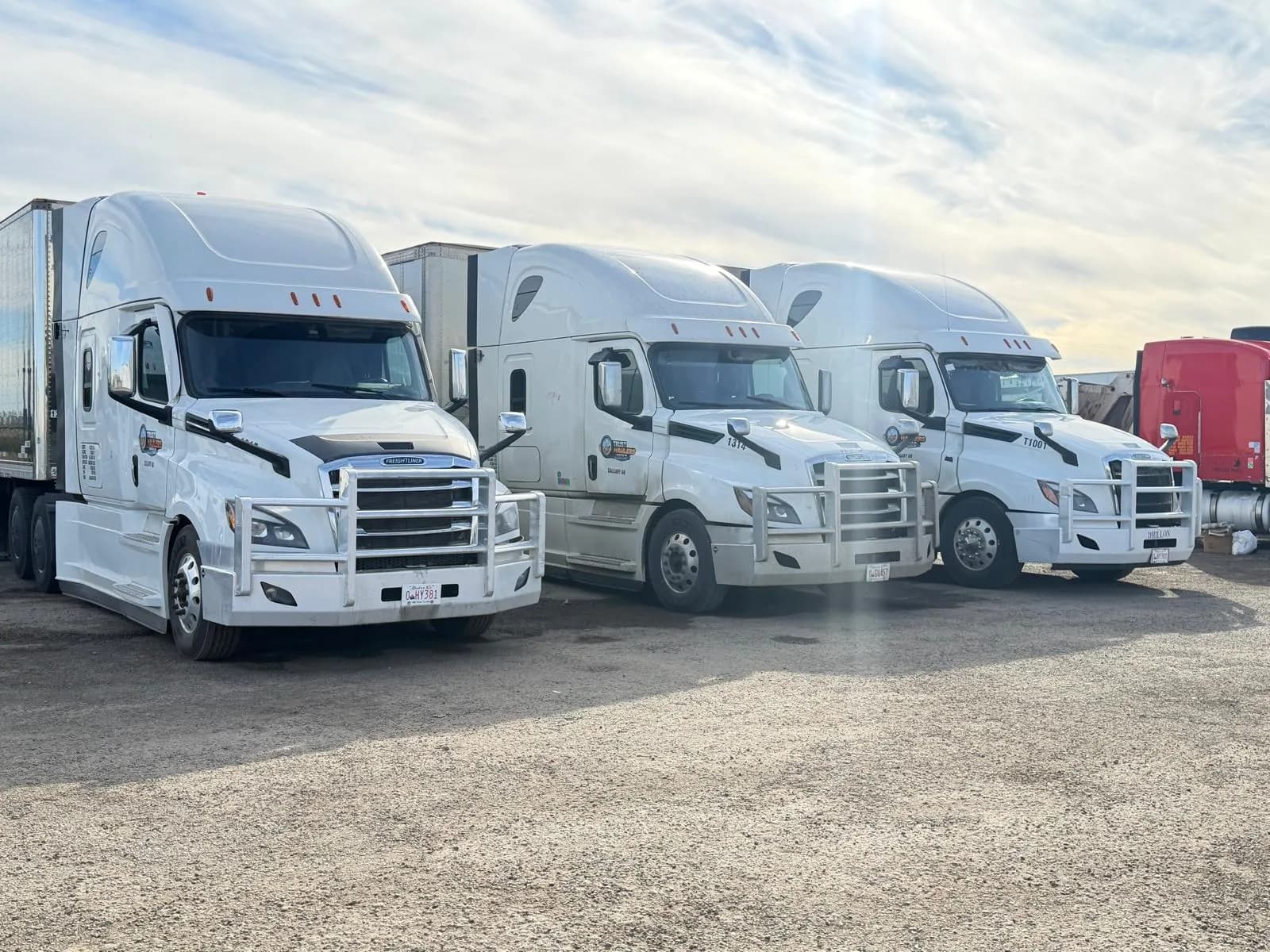Three Trust Haulers trucks and trailers lined up in the fleet yard